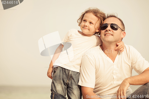 Image of Father and son playing on the beach at the day time.