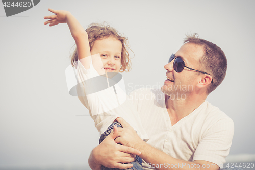 Image of Father and son playing on the beach at the day time.