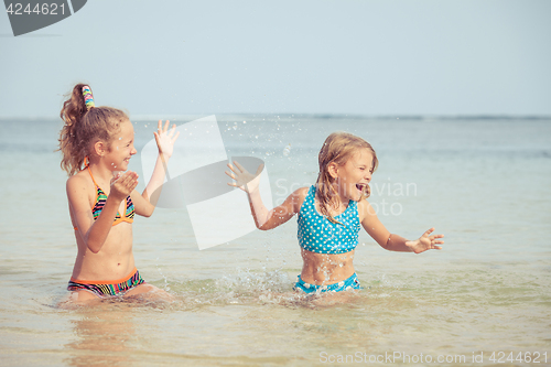 Image of Two happy children  playing on the beach