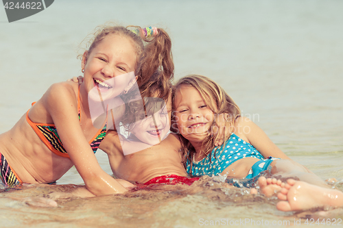 Image of Three happy children  playing on the beach