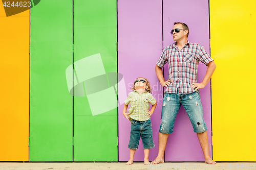 Image of Father and son playing near the house at the day time.