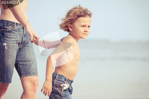 Image of Mother and son playing on the beach at the day time.