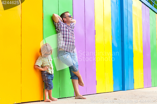 Image of Father and son relaxing near the house at the day time.