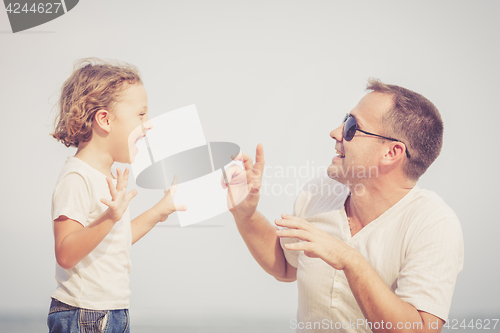 Image of Father and son playing on the beach at the day time.