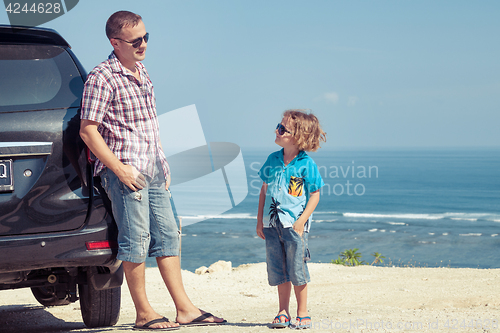 Image of Father and son playing on the beach at the day time.