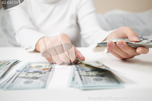Image of Close up of woman with calculator counting money