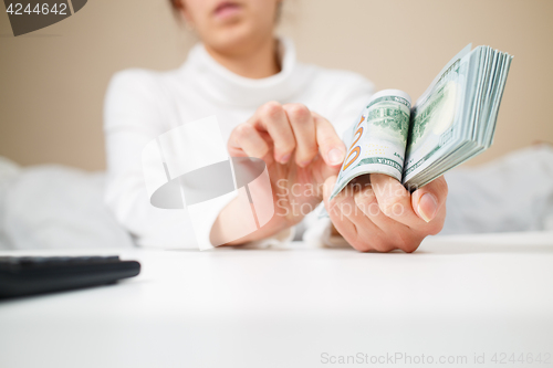 Image of business, finance, saving, banking and people concept - close up of woman hands counting us dollar money