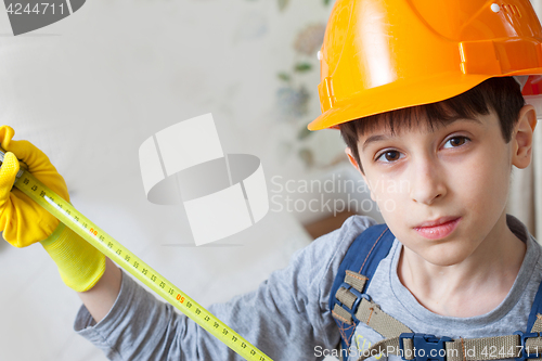 Image of boy in a protective helmet with a measuring tape