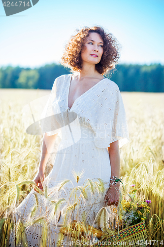 Image of Beautiful woman dressed in a white dress among the ears in the f