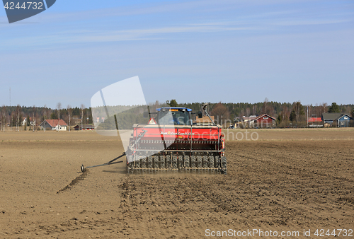 Image of Tractor and Seeder on Field at Spring