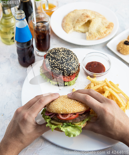 Image of Man eating burgers