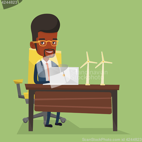 Image of Man working with model wind turbines on the table.