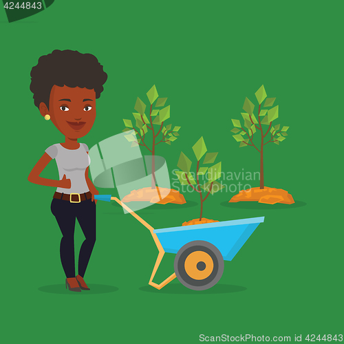 Image of Woman pushing wheelbarrow with plant.