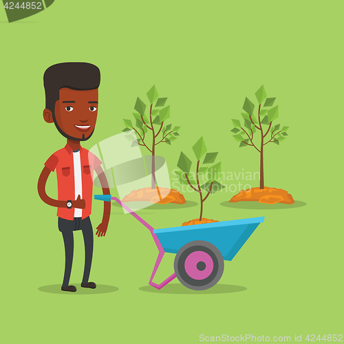 Image of Man pushing wheelbarrow with plant.