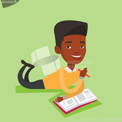 Image of Student laying on the floor and reading book.