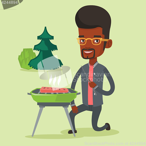 Image of Man cooking steak on barbecue grill.