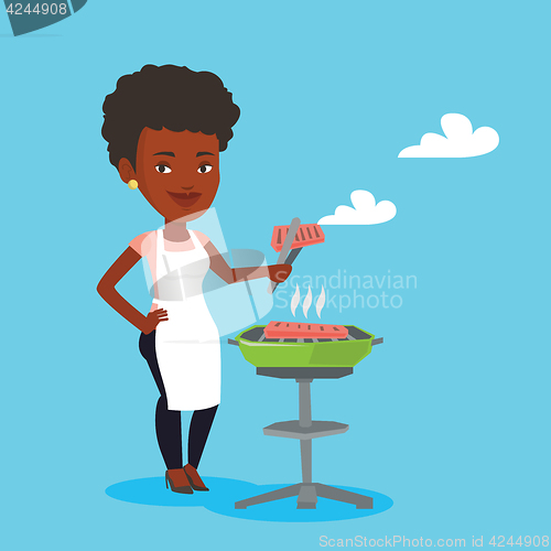 Image of Woman cooking steak on barbecue grill.