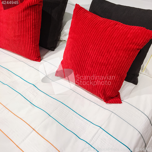 Image of Bed with red and black velveteen cushions