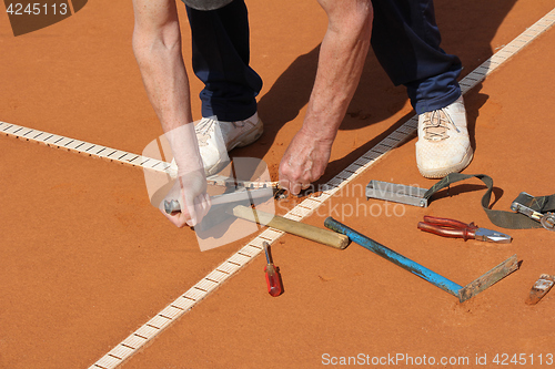 Image of Worker Repairing lines on a tennis court