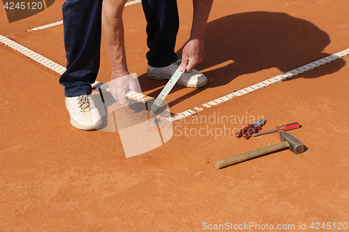 Image of Worker Repairing lines on a tennis court