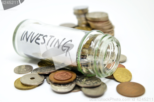Image of Investment lable in a glass jar with coins spilling out