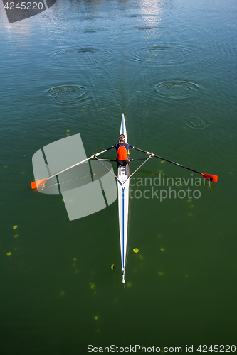 Image of Young woman rowing in boat on the lake