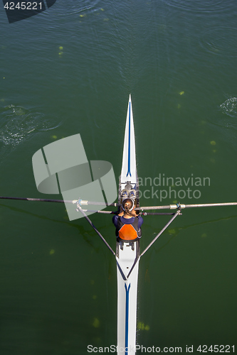 Image of Young woman rowing in boat on the lake