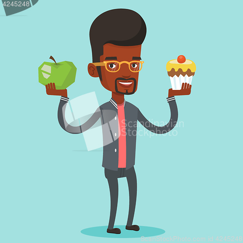 Image of Man choosing between apple and cupcake.