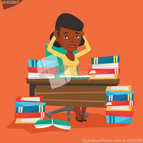 Image of Student sitting at the table with piles of books.