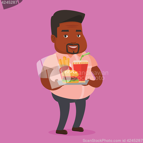 Image of Man holding tray full of fast food.