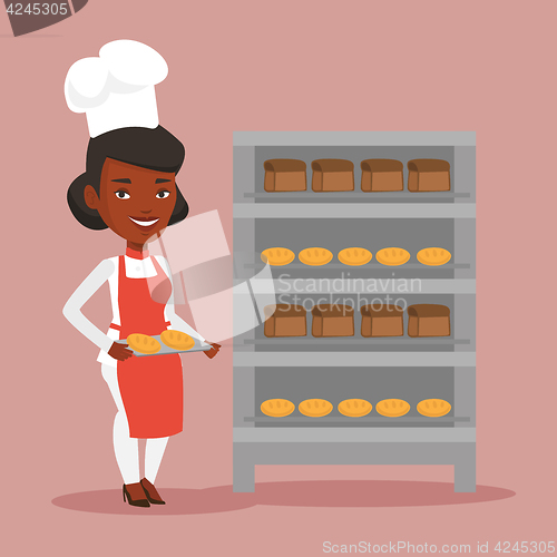 Image of Happy young female baker holding tray of bread.