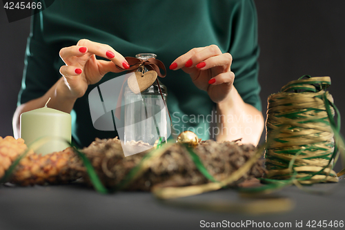 Image of Christmas house decoration. Christmas. Woman packs a Christmas gift and decorating the house with Christmas decorations 