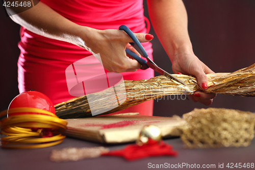 Image of Satin ribbon. The woman cuts the ribbon with scissors