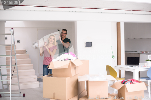 Image of couple carrying a carpet moving in to new home