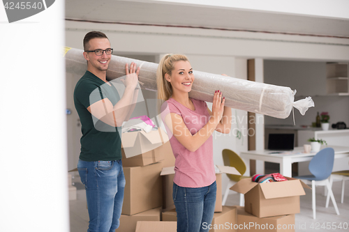 Image of couple carrying a carpet moving in to new home