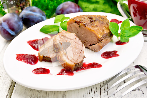 Image of Duck breast with plum sauce in plate on light board