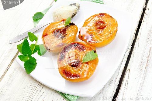 Image of Quince baked with ice-cream and mint in plate on light board