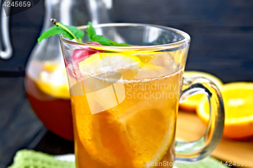 Image of Lemonade with cherries in wineglass and jug on table