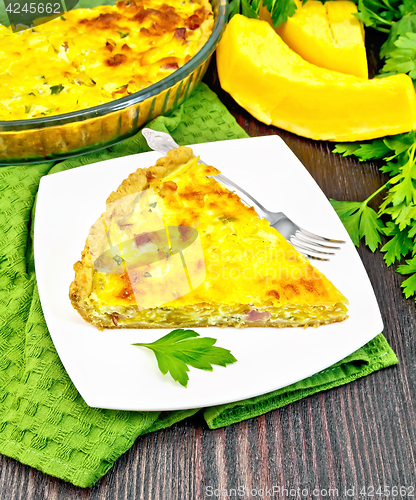 Image of Quiche with pumpkin and bacon in plate on green towel