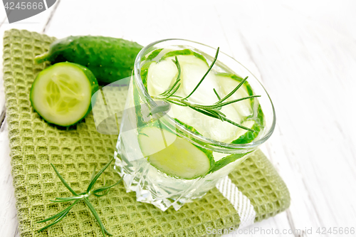 Image of Lemonade with cucumber and rosemary in glassful on green napkin