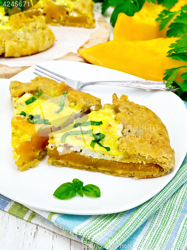 Image of Pie of pumpkin and basil in plate on light board