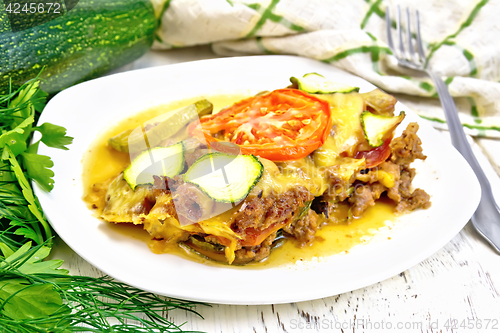 Image of Casserole from minced meat and zucchini in plate on light board