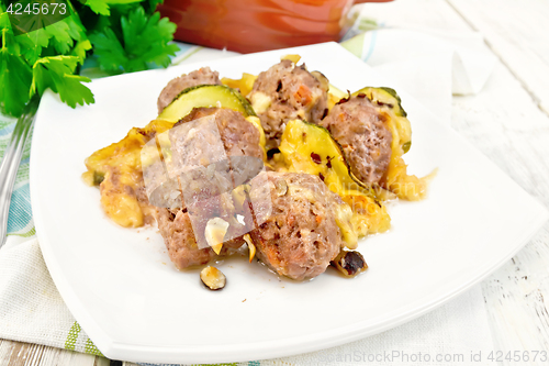 Image of Meatballs with zucchini and nuts in plate on board