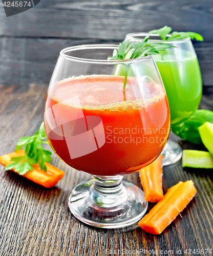 Image of Juice carrot and cucumber in two wineglass on dark board