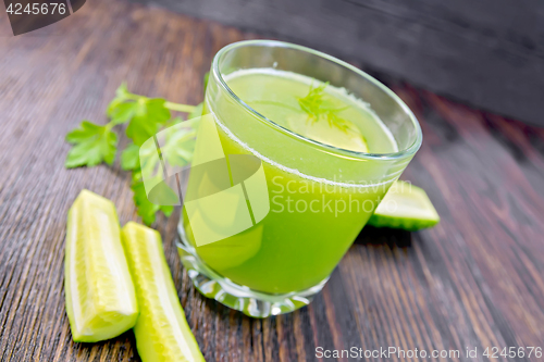 Image of Juice cucumber in glassful with vegetables on dark board