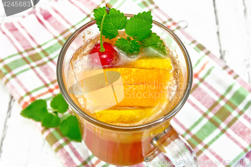 Image of Lemonade with cherry and orange in wineglass on board