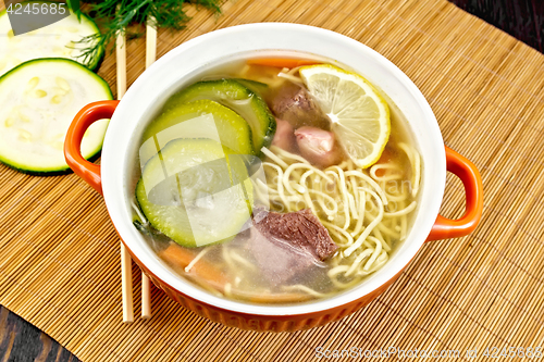 Image of Soup with zucchini and noodles on bamboo napkin