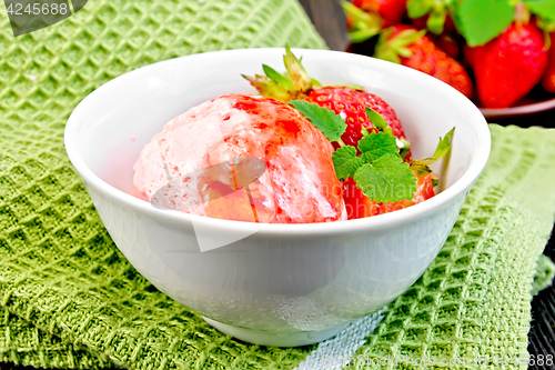 Image of Ice cream strawberry with syrup in bowl on green napkin