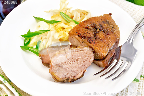 Image of Duck breast with cabbage and onions in plate on light board