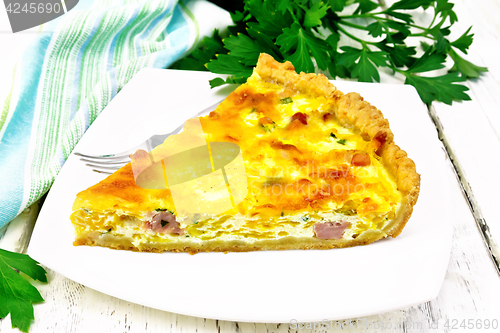 Image of Quiche with pumpkin and bacon in white plate on light board